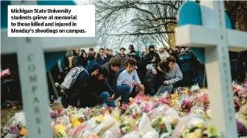  ?? ?? Michigan State University students grieve at memorial to those killed and injured in Monday’s shootings on campus.