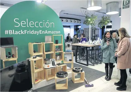  ?? EPA-EFE ?? Customers look at products at a pop-up Amazon store during its opening in Madrid on Wednesday.