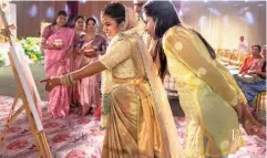  ?? SPECIAL ARRANGEMEN­T ?? Works to be cherished (Clockwise from left) Dhanushya Pallem painting at a wedding; Keerthana Adepu (in salwar) looks at her art with the bride and groom; Chennai-based Srishti Prabakar’s canvas.