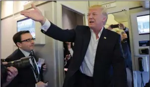  ?? The Associated Press ?? TRUMP: President Donald Trump talks to reporters on board Air Force One as he arrived to speak at his "Make America Great Again Rally" Saturday at Orlando-Melbourne Internatio­nal Airport in Melbourne, Fla.