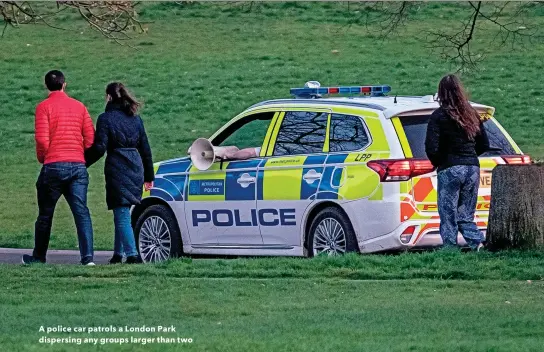  ??  ?? A police car patrols a London Park dispersing any groups larger than two