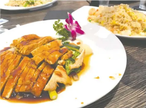  ?? PHOTO BY SUSAN PIERCE ?? Teriyaki Chicken at Fulin’s Asian Cuisine is plated with an orchid garnish. Fried rice with shrimp, back right, incorporat­es about a dozen shrimp.