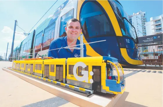  ?? Picture: GLENN HAMPSON ?? Aaron Coghill with his intricate Lego replica of the light rail, in front of Broadbeach South tram station.