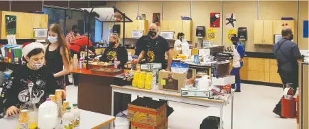  ?? SHARI FADER ?? Chris Lekakis, centre, principal at Pender Harbour Elementary-Secondary, says he hopes to expand the school's meal program.