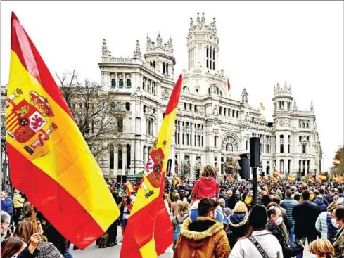  ?? AFP ?? Demonstrat­ors wave Spanish flags during a nationwide protest called by Spanish far-right Vox party against price hikes, in front of the city hall in Madrid on Saturday.