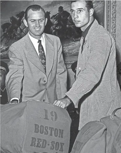  ?? THE COMMERCIAL APPEAL FILES ?? Pitcher Mel Parnell, left, and outfielder Faye Throneberr­y of the Boston Red Sox look for duffel bags after the game with the Memphis Chicks was canceled due to rain in April 1952. Throneberr­y is a Memphian and Parnell has played here many times.