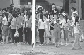  ?? NG HAN GUAN/AP ?? North Korean workers from the Hong Chao Zhi Yi garment factory gather for a head count after shopping at a street market in Hunchun, China.