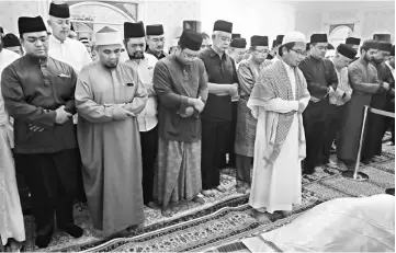  ??  ?? Najib (fourth left front row) and others joining in the prayer session when paying last respects to Adenan at his home in Santubong on Wednesday night. — Photos by Jeffery Mostapa