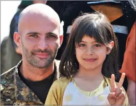  ??  ?? MISSION: Daniel Burke poses with one of the local children while in Syria