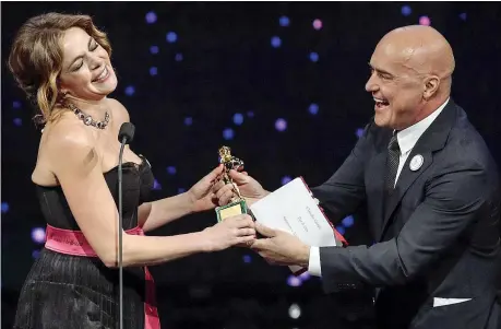  ??  ?? Claudia Gerini L’attrice (46 anni) riceve dalle mani di Luca Zingaretti il David di Donatello come miglior attrice non protagonis­ta per «Ammore e malavita» dei Manetti Bros. Il film era in gara per il Leone d’oro al Festival di Venezia