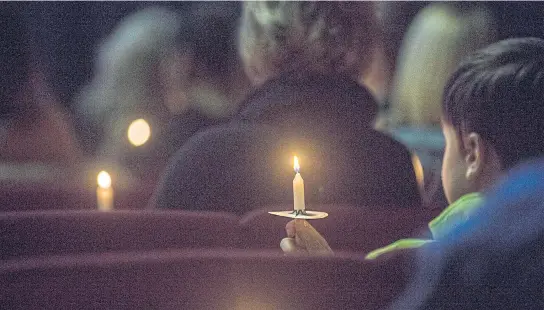  ?? AP ?? People hold candles during a vigil at Impact Church in Benton, Kentucky on Tuesday. The vigil was held for victims of the Marshall County High School shooting earlier in the day.
