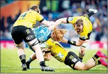  ??  ?? Auckland Blues player Tom Robinson, (in blue), is tackled by the defence during the Super Rugby Aotearoa rugby match between the Blues and the
Hurricanes at Eden Park, in Auckland, New Zealand, on June 14. (AP)