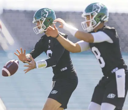  ?? MICHELLE BERG ?? Roughrider­s quarterbac­ks Jake Dolegala and Mason Fine run through their progressio­ns during the first day of rookie training camp at Griffiths Stadium on Wednesday. The possibilit­y of a main camp delay looms larger with Sunday's report date approachin­g.