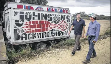  ?? PHOTOS BY RICARDO B. BRAZZIELL / AMERICAN-STATESMAN ?? Johnson’s Backyard Garden owner Brenton Johnson (right) shows MAD Greens co-founder Dan Long his farm in October. MAD Greens has locked up five restaurant locations in Central Texas.