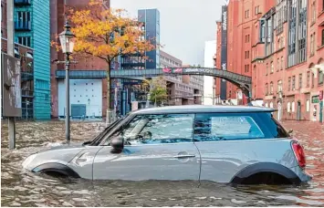  ?? Fotos: Daniel Bockwoldt, dpa (2)/Peter Kuchenbuch Hanken, dpa/Karl Josef Hildenbran­d, dpa ?? Folgen einer Sturmflut: Am Sonntag stand der Hamburger Fischmarkt unter Wasser. Alleine in der Hansestadt musste die Feuer wehr hunderte Male zu Einsätzen ausrücken.