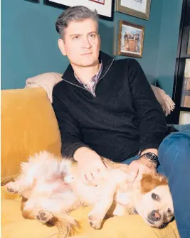  ?? MICHELLE GROSKOPF/THE NEW YORK TIMES ?? Michael Schur, creator of “The Good Place,” is seen at home with his dog Henry on Dec. 17 in Los Angeles. He recently released his first book.