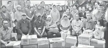  ??  ?? Fatimah (second row centre) together with others in a photocall in front of the razed houses after presenting the assistance.