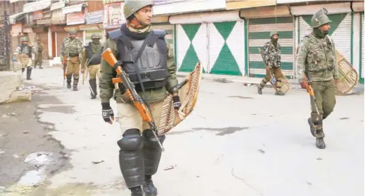  ?? Associated Press ?? Paramilita­ry soldiers patrol a closed market area during a strike in Srinagar on Saturday. SRINAGAR: