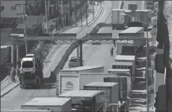  ?? TRIBUNE NEWS SERVICE ?? Trucks line up on Oct. 6 by the U.S. border fence in Tijuana to cross to the United States at Otay Mesa.