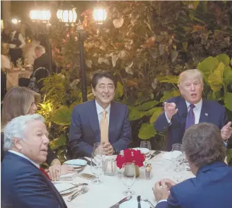  ?? AFP GETTY IMAGES/NICHOLAS KAMM ?? FORMAL DINNER: President Trump, top right, joins Japanese Prime Minister Shinzo Abe, center, first lady Melania Trump, obscured at left and Patriots owner Robert Kraft, below left, at Trump’s Mar-a-Lago resort last night.