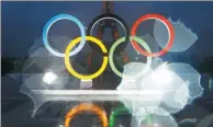  ?? FRANCOIS MORI / AP ?? A photo taken with a lens covered with rain drops shows the reflection of the Olympic rings on Place du Trocadero, overlookin­g the Eiffel Tower in Paris on Wednesday. The French capital will host the 2024 Summer Games.