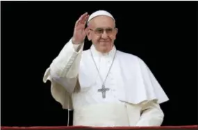  ?? THE ASSOCIATED PRESS ?? Pope Francis waves to faithful prior to delivering the Urbi et Orbi (Latin for “to the city and to the world”) Christmas day blessing from the main balcony of St. Peter’s Basilica at the Vatican on Sunday.