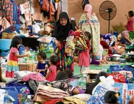  ?? —PHOTOS BY JASON GUTIERREZ ?? DREAMING OFHOME Alinor Tarip and daughter Hamida (left). Marawi evacuees find their own space in a packed evacuation camp in Balo-i, Lanao del Norte.