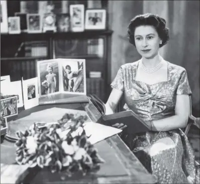  ??  ?? The Queen in a gold lamé dress delivering her Christmas Day message to the Commonweal­th at Sandringha­m in 1957.