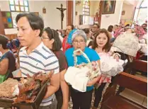  ??  ?? Entrega. Como parte de la tradición, Santa Juana recibe a los niños dioses de parte de los feligreses.