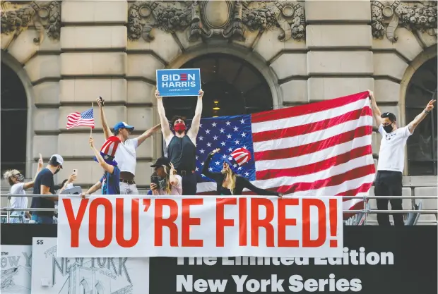  ?? ANDREW KELLY / REUTERS ?? People ride down New York City’s Fifth Avenue in an open top double- decker bus Sunday as they celebrate Joe Biden’s victory over Donald Trump.