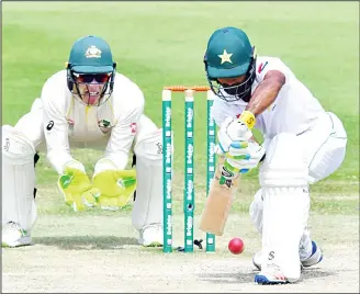  ?? (AFP) ?? Pakistan cricketer Asad Shafiq (right), plays a shot as Australian wicketkeep­er Tim Paine looks on during day three of the second Test cricket match in the series between Australia and Pakistan at the Abu Dhabi Cricket Stadiumin Abu Dhabi on Oct 18.