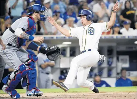  ?? Denis Poroy Getty Images ?? HUNTER RENFROE of the Padres scores ahead of the throw to Yasmani Grandal of the Dodgers, giving San Diego a 3-2 lead in the first inning. Renfroe drove in four runs in the Padres’ 6-5 victory, one night after driving in seven. D5