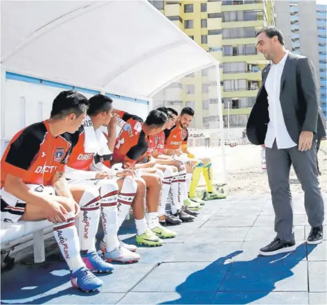  ?? FOTO: PHOTOSPORT ?? ►► Pablo Guede sonríe con sus jugadores en la banca del estadio Cavancha, en Iquique.