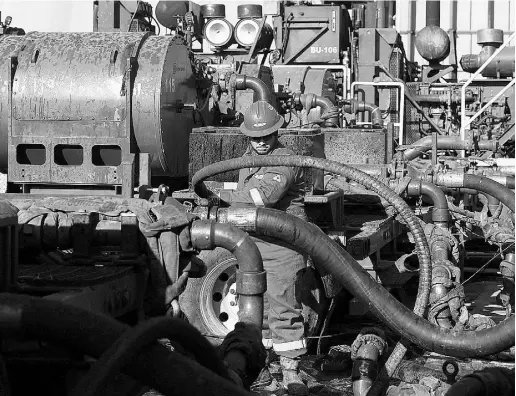  ?? Brenan Linsley / The Associate d Pres Files ?? A worker adjusts hoses at an Encana Corp. gas well, near Mead, Colo. The Calgary-based producer said it cut
an additional 200 jobs as the fight over market share instigated by Saudi Arabia drags on.