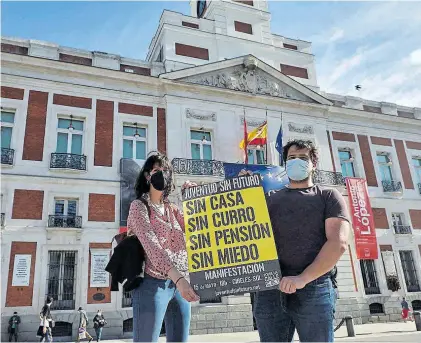  ??  ?? Juan y Silvia posan en la Puerta del Sol con uno de los carteles anunciador­es de la concentrac­ión del 2011. ANA MÁRQUEZ