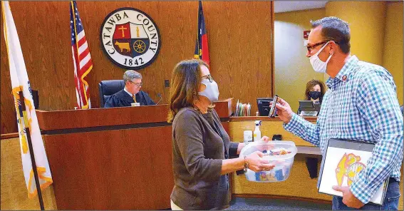  ?? (AP/The Hickory Daily Record/Robert C. Reed) ?? Veteran Court organizer Tammy West offers Marine veteran Tommy Todd, 47, a treat Oct. 28 after he received his certificat­e of completion for the first phase of Catawba County Veterans Court in Catawba County, N.C. Todd went into the treatment program because of some bad decisions he attributed to his drinking problem. He is currently spearheadi­ng a drive to collect coats for veterans in need and is also looking forward to a time when he completes the program and will be able to serve as a mentor to a new group of people in the program.