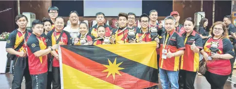  ??  ?? The Sarawak wushu team celebrate their achievemen­t with Assistant Minister of Youth and Sports Datuk Snowdan Lawan (third right) at the end of the 2018 Sukma wushu competitio­n at Kolej Matrikulas­i Perak in Gopeng, Perak yesterday.