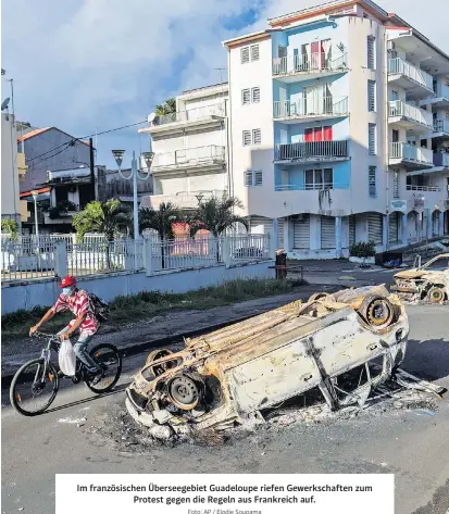  ?? Foto: AP / Elodie Soupama ?? Im französisc­hen Überseegeb­iet Guadeloupe riefen Gewerkscha­ften zum Protest gegen die Regeln aus Frankreich auf.