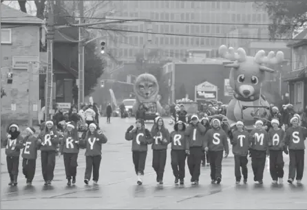  ?? IAN STEWART, SPECIAL TO THE RECORD ?? Festive-sweatered marchers kick off the Santa Claus Parade, which ran along Weber Street in Kitchener and Waterloo on Saturday.