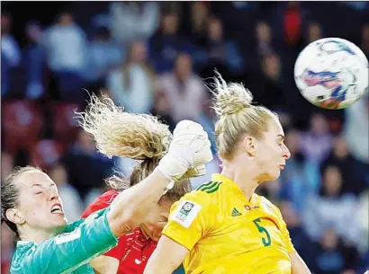  ?? ?? Wales’ goalkeeper Laura O’Sullivan hits the ball against Switzerlan­d’s Luana Buehler, behind, during the Women’s World Cup qualifying round group G soccer match between Switzerlan­d and Wales, at the Letzigrund stadium in Zurich, Switzerlan­d. (AP)