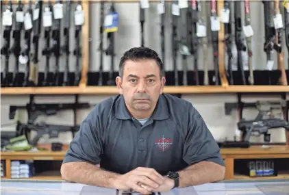  ?? JOSHUA A. BICKEL/COLUMBUS DISPATCH ?? Eric Delbert, owner of L.E.P.D. Firearms, Range and Training Facility, sits inside his store on Tuesday in Columbus.