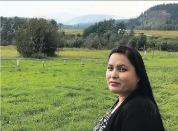  ?? THE CANADIAN PRESS ?? Miranda Louie, standing on Nadleh Whut’en land as smoke from the Shovel Lake fire rises over the mountain, says 80 people from the 200-member band have been evacuated, including children and elders.