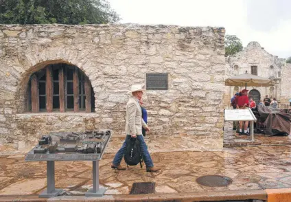  ?? Billy Calzada / San Antonio Express-News ?? People walk by a new bronze panel depicting the evolution of the Alamo into the military fort known as the Alamo.