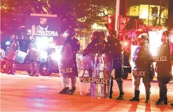  ?? RICK WOOD AP ?? Protesters march in Wauwatosa, Wis., around a line of National Guardsmen protecting City Hall late Wednesday after District Attorney John Chisolm refused to issue charges in the fatal shooting of 17-year-old Alvin Cole.