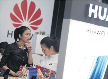  ?? SOMCHAI POOMLARD ?? Visitors browse Huawei smartphone­s at Thailand Mobile Expo 2019.