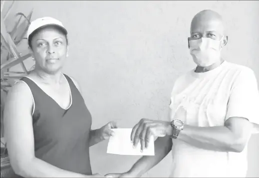  ?? ?? Widow of the late Wilbert Benjamin, Evette Benjamin, (left), hands over the sponsorshi­p cheque to president and coach of the Flying Ace Cycle Club, Randolph Roberts.