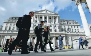  ?? BEN STANSALL / FOR CHINA DAILY ?? Pedestrian­s walk past the Bank of England in London.