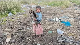  ??  ?? Una niña camina en la orilla del río Titicaca, en Perú. Los gobiernos de este país y de Bolivia firmaron en enero un pacto para combatir la polución en la zona.