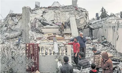  ?? AFP ?? Demolición. Un grupo de palestinos observan los restos de una vivienda en el enclave de Gaza.