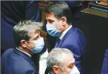  ?? GUGLIELMO MANGIAPANE / REUTERS ?? Italian Prime Minister Giuseppe Conte (right) wins a confidence vote in the Chamber of Deputies in Rome on Monday.